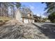 Three car garage with brick accents and a concrete driveway surrounded by mature trees at 6301 King Lawrence Rd, Raleigh, NC 27607