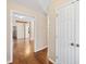 Hallway with hardwood floors, white doors, and an open doorway to the living area at 6301 King Lawrence Rd, Raleigh, NC 27607