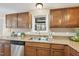 Kitchen with updated appliances, wooden cabinetry, and granite countertops with a view from the window at 6301 King Lawrence Rd, Raleigh, NC 27607