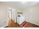 Laundry room with white washer and dryer, shelving with baskets, a rug, and hardwood floors at 6301 King Lawrence Rd, Raleigh, NC 27607