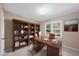 Office featuring a large wood desk, bookcase, decor, plush rug, and a sun-filled window with outdoor views at 6301 King Lawrence Rd, Raleigh, NC 27607