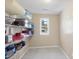 Well-organized pantry with white shelving stocked with various kitchen items and a window at 6301 King Lawrence Rd, Raleigh, NC 27607