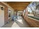 Enjoy a sunny afternoon on the porch, featuring comfortable seating and lovely brick accents at 6301 King Lawrence Rd, Raleigh, NC 27607