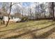 Spacious backyard with a well-maintained lawn, wooden fence, and a view of the house and the surrounding trees at 6913 Baywood Dr, Raleigh, NC 27613