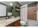 Elegant bathroom with granite vanity, decorative shelves and a shower-tub combo at 6913 Baywood Dr, Raleigh, NC 27613
