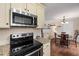 Open kitchen area with stainless appliances and view of the dining area and living room at 6913 Baywood Dr, Raleigh, NC 27613