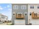 Backyard view of the exterior of a two-story townhome featuring a small deck and a two-car garage at 709 Lucky Clover Way, Fuquay Varina, NC 27526