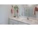 Bathroom featuring a double sink vanity, a large mirror, and decorative plants with a glass enclosed shower at 709 Lucky Clover Way, Fuquay Varina, NC 27526