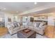 Spacious living room with a large sectional couch, a view into the bar area, and wood floors at 710 Legacy Falls S S Dr, Chapel Hill, NC 27517