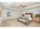 Comfortable main bedroom with a tray ceiling, ceiling fan, and large windows at 710 Legacy Falls S S Dr, Chapel Hill, NC 27517