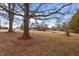 View of a house with a screened-in porch and a deck, set within a spacious, tree-lined backyard at 7415 Old Oxford Rd, Bahama, NC 27503
