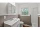 This bathroom features a white vanity, a window above the toilet, and painted walls at 7415 Old Oxford Rd, Bahama, NC 27503