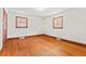 The bedroom features hardwood floors, two windows offering plenty of natural light, and neutral wall colors at 7415 Old Oxford Rd, Bahama, NC 27503