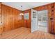 The dining room has wood paneling and flooring, complemented by a charming chandelier and natural light at 7415 Old Oxford Rd, Bahama, NC 27503