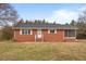 Charming brick home featuring a screened-in porch and well-maintained lawn at 7415 Old Oxford Rd, Bahama, NC 27503