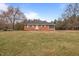 Charming one-story brick house with a well-maintained front yard and mature trees on a sunny day at 7415 Old Oxford Rd, Bahama, NC 27503
