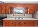 The kitchen features beautiful wood cabinets, a stainless steel sink, and a window with a lovely outdoor view at 7415 Old Oxford Rd, Bahama, NC 27503