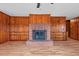 Cozy living room featuring a brick fireplace, built-in shelving, and wood paneled walls at 7415 Old Oxford Rd, Bahama, NC 27503