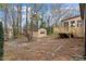 Large backyard with mature trees, storage shed, and wooden deck with steps at 7725 Longstreet Dr, Raleigh, NC 27615