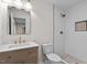 Renovated bathroom with modern vanity, gold hardware, white subway tile shower with rainfall shower head at 7725 Longstreet Dr, Raleigh, NC 27615