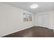 A bedroom with hardwood floors and a window overlooking the front yard and double-door closet at 7725 Longstreet Dr, Raleigh, NC 27615