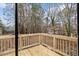 View of the wooden deck and backyard with lush trees; the deck is surrounded by a wooden railing at 7725 Longstreet Dr, Raleigh, NC 27615