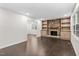 Spacious living room boasting hardwood floors, built-in shelving, and a striking stone fireplace at 7725 Longstreet Dr, Raleigh, NC 27615