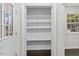 A spacious pantry with ample shelving for storage and dark hardwood floors can be seen through the open doors at 7725 Longstreet Dr, Raleigh, NC 27615