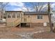 Rear exterior view of the house with a wooden deck and a brick foundation at 7725 Longstreet Dr, Raleigh, NC 27615