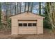 Exterior view of a storage shed with a roll-up door in the backyard at 7725 Longstreet Dr, Raleigh, NC 27615