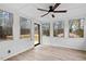 This sun room features floor to ceiling windows and wainscoting, with a ceiling fan to keep the room cool at 7725 Longstreet Dr, Raleigh, NC 27615