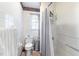 Bright bathroom with a white toilet, patterned border, stainless trash can, and shower curtain at 805 S 11Th St, Lillington, NC 27546