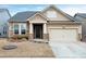 Charming one-story home featuring stone accents, a welcoming front porch, and an attached garage at 823 Atticus Way, Durham, NC 27703