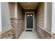Covered front entryway featuring stone detail, a decorated door, and a concrete entry at 823 Atticus Way, Durham, NC 27703