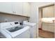 Well-lit laundry room featuring white washer and dryer and built in white cabinets for ample storage at 823 Atticus Way, Durham, NC 27703