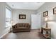 Neutral living room features a brown sofa, a window with white trim, and two lamps at 823 Atticus Way, Durham, NC 27703