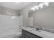 Modern bathroom with a sleek vanity, granite countertop, and a shower-tub combination at 8341 Wynewood Ct, Raleigh, NC 27616