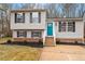 Charming split-level home with a manicured front yard, blue door, and black shutters at 8341 Wynewood Ct, Raleigh, NC 27616