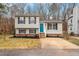 Split-level home with tidy landscaping and a vibrant blue front door at 8341 Wynewood Ct, Raleigh, NC 27616