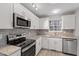 Contemporary kitchen with white cabinets, stainless steel appliances, and stylish backsplash at 8341 Wynewood Ct, Raleigh, NC 27616