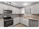 Bright kitchen featuring white cabinets, stainless steel appliances, and modern countertops at 8341 Wynewood Ct, Raleigh, NC 27616