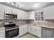 Updated kitchen features stainless steel appliances, white cabinets, and granite countertops at 8341 Wynewood Ct, Raleigh, NC 27616
