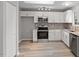 This modern kitchen offers stainless appliances, granite counters, and bright white cabinets at 8341 Wynewood Ct, Raleigh, NC 27616