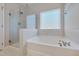 Relaxing bathroom with a soaking tub and a separate tiled shower with a glass door at 84 Nonabell Ln, Four Oaks, NC 27524