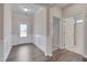 Bright foyer with white wainscoting, hardwood floors, and an open doorway at 84 Nonabell Ln, Four Oaks, NC 27524
