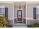 Elegant front entrance features a black door with glass panes and stone accents at 84 Nonabell Ln, Four Oaks, NC 27524