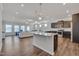 Open-concept kitchen features a large island, dark cabinets, and stainless steel appliances at 84 Nonabell Ln, Four Oaks, NC 27524