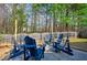 Backyard with stone-paved patio and adirondack chairs surrounding a cozy fire pit for cool evenings at 912 Homestead Park Dr, Apex, NC 27502