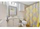 Bathroom with granite countertop vanity, framed mirror, tile flooring, and yellow decorative shower curtain at 912 Homestead Park Dr, Apex, NC 27502