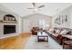 Bright living room featuring gleaming hardwood floors, fireplace, and comfortable leather seating at 912 Homestead Park Dr, Apex, NC 27502